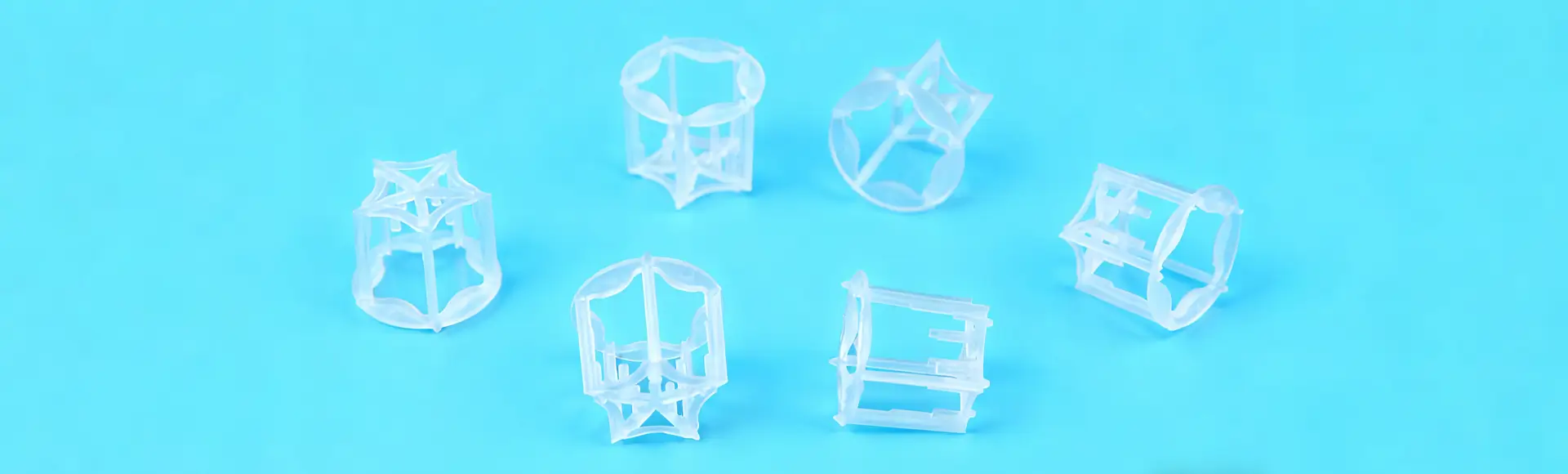 Six plastic pentagon rings lying on the black glass in different condition.