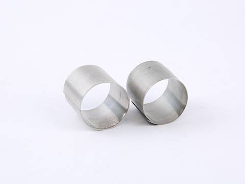 Two stainless steel metal raschig ring on white background.