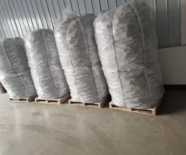 Four stacks of packaged random packing materials by a factory wall