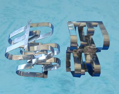Two metal super raschig rings on a blue background.