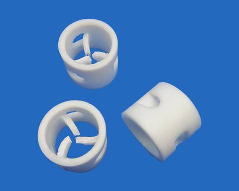 Three PTFE pall ring on blue background with two standing and one lying.