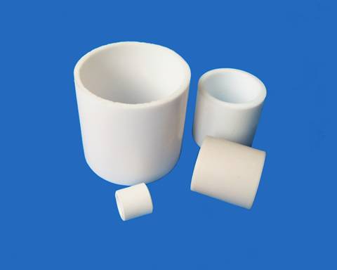 Four different sizes of ptfe raschig ring on blue background.